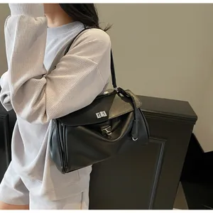 Detail of black leather underarm bag featuring silver twist lock and textured finish