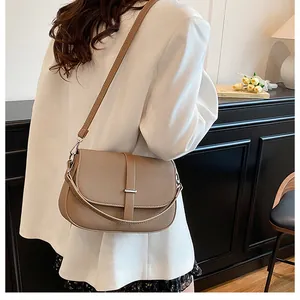 Detail of a brown woven texture crossbody bag with silver buckle and elegant shoulder strap