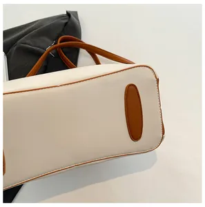 Detailed close-up showing the oval reinforced base and contrast stitching of the tote bag