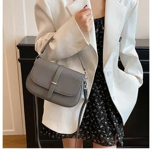 Detailed view of the gray crossbody bag with metal buckle and slim shoulder strap