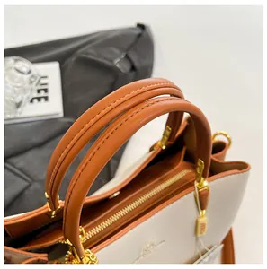 Detail of high-quality leather handbag showing stitching, gold zipper, and round handle