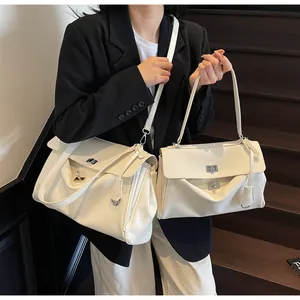 Detail showing two sizes of white vintage shoulder bags with silver metal turn-lock closures