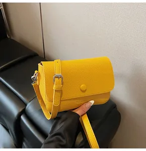 Détails du sac jaune en cuir grainé avec bouton circulaire et fermoir en métal argenté