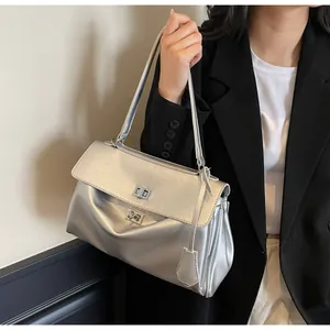 Detail of silver metallic shoulder bag with turn-lock clasp and accordion side pleats