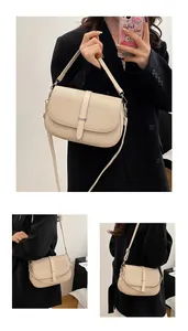 Detail view of the beige crossbody bag featuring textured synthetic leather and metal buckle
