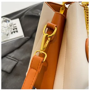 Close-up of golden metal hardware and premium stitching on the bicolor leather handbag