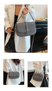 Detail view of a gray textured crossbody bag with flip cover and adjustable shoulder strap