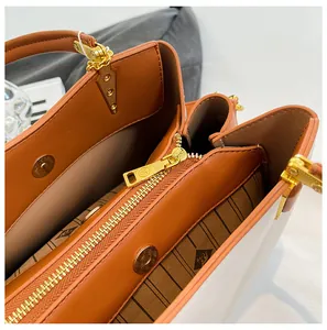 Macro view of multi-compartment interior with striped lining and gold hardware on tote