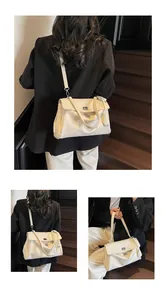 Detail of minimalist beige underarm bag with silver twist lock and smooth leather texture