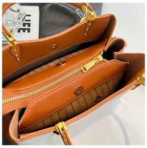 Top view of spacious interior of brown and white tote bag with gold magnetic snap and zipper