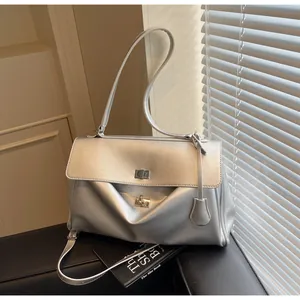 Detail of silver metallic shoulder bag showing the twist lock closure and leather texture