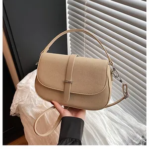 Detail showing the woven texture of the beige crescent handbag with leather buckle strap