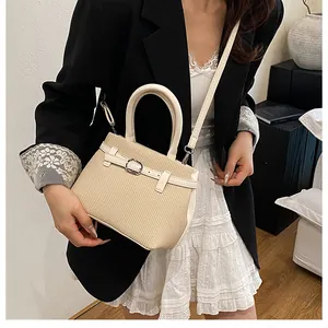 Straw texture beige handbag with leather handles styled with a black blazer dress