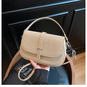 Detail of beige woven texture handbag with leather straps and silver metal buckle