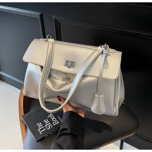 Detail view of silver metallic bag featuring dual silver turn-lock buckles and fine texture