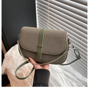 Detailed view of the vintage saddle bag showing olive green fabric and leather trim