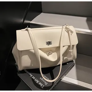 Close-up of off-white faux leather handbag with silver turn-lock and dual straps
