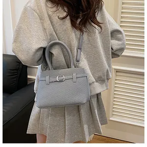 Detail of light blue-grey woven textured handbag with silver buckles and slim strap