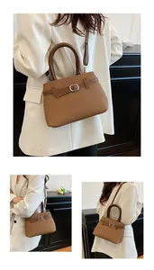 Detailed view of brown woven texture handbag with leather straps and silver buckle