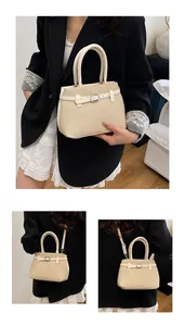 Close-up of beige woven texture handbag with leather trim and round handles detail