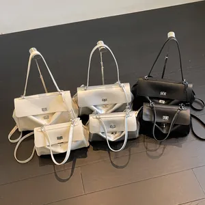 Minimalist leather shoulder bags in white, silver, and black with metallic hardware