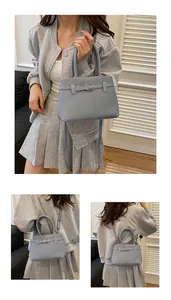 Detail of light blue woven handbag with metallic buckle and detachable shoulder strap