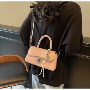 Detailed view of the pink faux leather square bag with silver rotary lock and strap