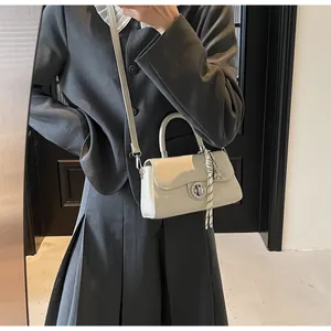 Detailed view of mini cream square bag with silver clasp and black white woven cord charm