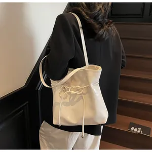 Mannequin portant un sac cabas blanc en cuir gaufré avec breloque cœur perle sur un escalier