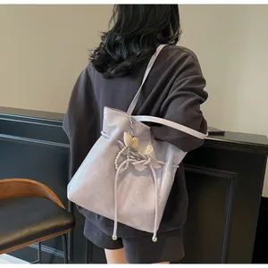 Détail d'un sac cabas lilas à texture froissée brillante avec nœud en perles élégant