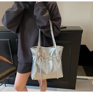 Détail du sac cabas argenté avec texture métallisée froissée et breloque perle et nœud