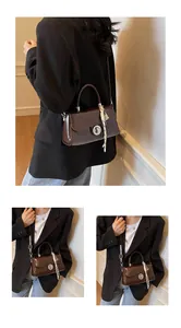 Detail of vintage brown leather bag with silver metal lock and woven rope charm