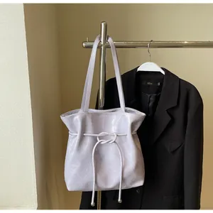 Détail du sac cabas lilas en similicuir avec cordon de serrage et boule métallique