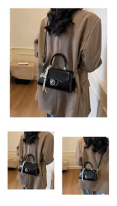Detail of black leather crossbody bag with silver twist lock and decorative silk scarf