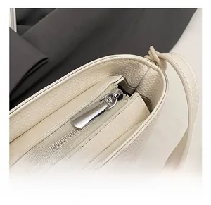 Gros plan du sac en cuir grainé avec détails de fermeture éclair en métal argenté poli