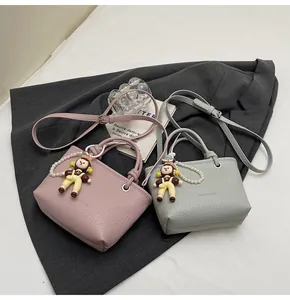 Detailed view of pink and grey litchi leather mini bags with elegant pearl charms