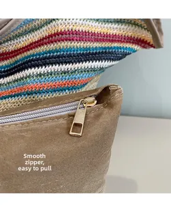 Macro detail of smooth golden metal zipper on brown suede woven shoulder handbag