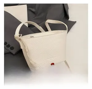 Détail du sac seau blanc avec texture cuir grainé et pendentif coeur argenté