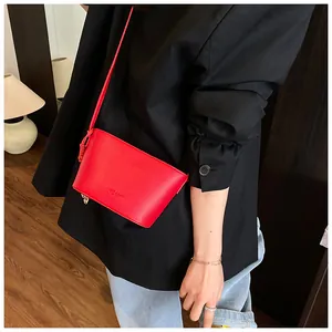 Détail du sac seau en cuir rouge vif avec des nœuds décoratifs sur les côtés