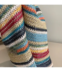 Detailed macro view of multi-color striped woven straw bag with precise white stitching