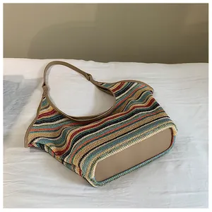 Detail of colorful woven knit hobo bag with wavy texture and khaki leather shoulder strap