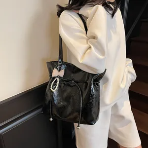 Sac cabas en cuir verni noir brillant avec cordon de serrage et breloque noeud perlé