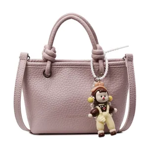 Pale mauve lychee pattern leather bucket bag with top handle and pearl doll charm
