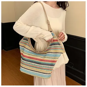 Detail of colorful striped woven hobo bag with beige shoulder strap for summer beach