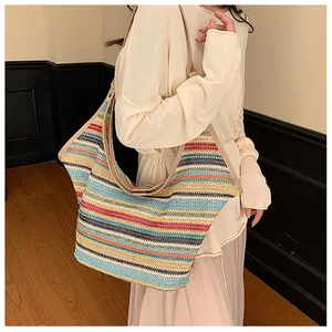 Detail of colorful striped woven straw tote bag with fine stitching on shoulder straps