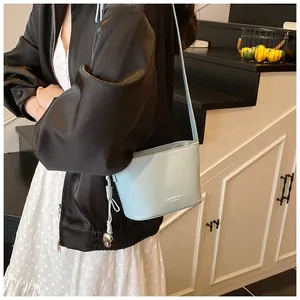 Détail du sac seau bleu clair avec pendentif en cœur et texture grainée lychee