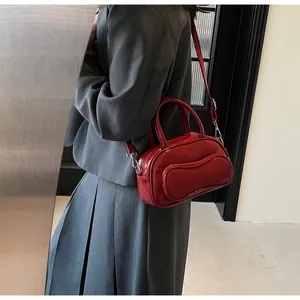 Close-up of bright red patent leather handbag with silver hardware in a lifestyle setting