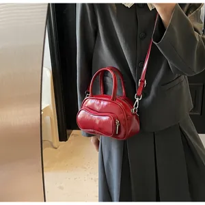 Fashionable red leather bowling bag with silver hardware on model in a mirror shot