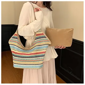 Rainbow striped woven tote bag and khaki clutch set shown on model in modern setting