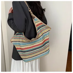 Close-up of a large woven tote bag with colorful stripes on a model's shoulder
